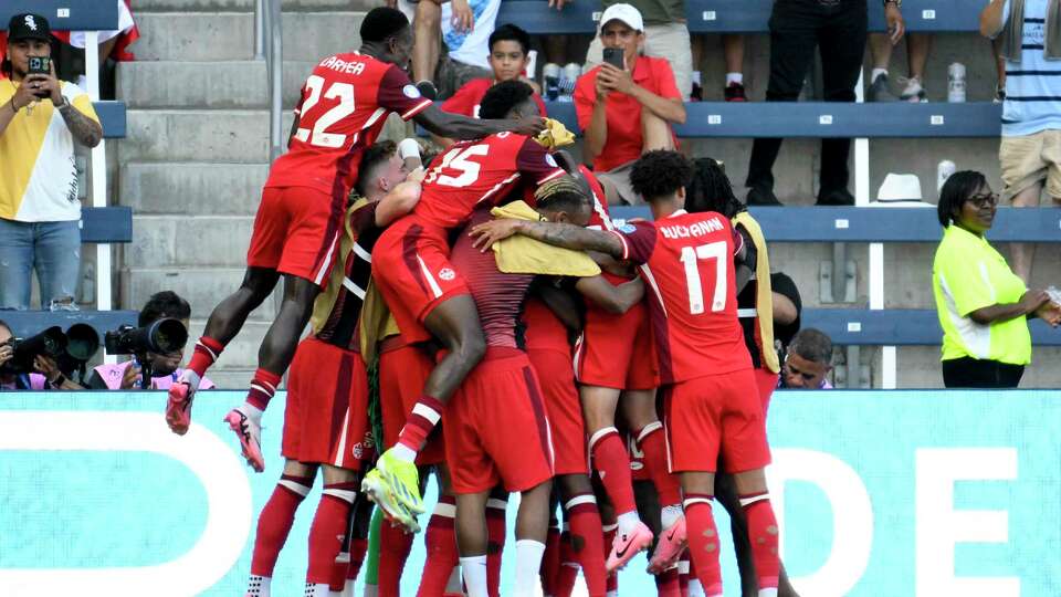 Canada's Jonathan David, not seen, celebrates scoring the opening goal against Peru with teammates during a Copa America Group A soccer match in Kansas City, Kan., Tuesday, June 25, 2024.