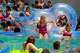 Taylor Kostelnik and Presley Kostelnik are pushed off the floating device by family as they float on the tidal wave river at Schlitterbahn in Galveston.