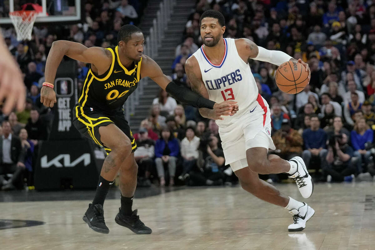 Los Angeles Clippers forward Paul George drives to the basket against Golden State Warriors forward Jonathan Kuminga during an NBA basketball game in San Francisco, Wednesday, Feb. 14, 2024.