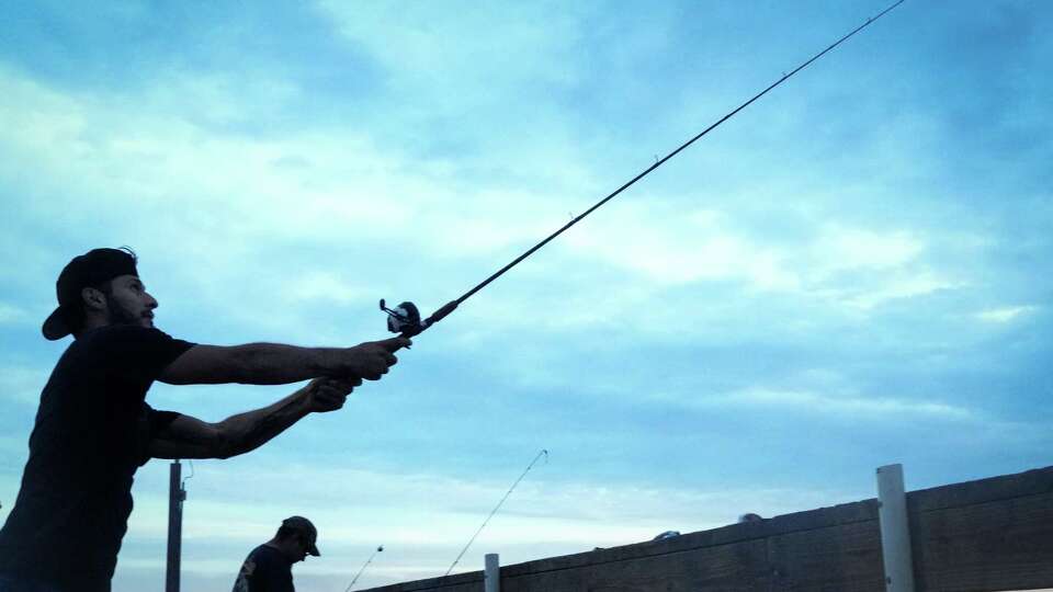 J.B. Fernandez, left, fishes with his cousin Daniel Fernandez, right, and uncle, not pictured, ahead of the expected landfall of Tropical Storm Beryl on Sunday, July 7, 2024, at the Port Lavaca fishing pier at Bayfront Peninsula Park in Port Lavaca. (Jon Shapley/Houston Chronicle)