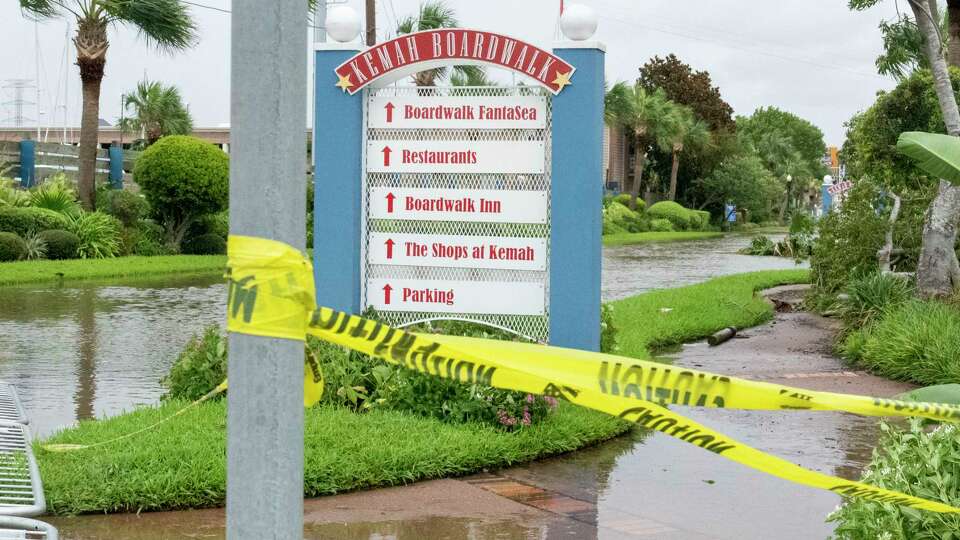 Caution tape warns pedestrians as the road leading to the entrance of the Kemah Boardwalk is closed due to flooding from Galveston Bay after Hurricane Beryl made landfall early morning Monday, July 8, 2024, near Matagorda.