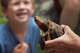 Environmental Education Supervisor Emily Carreiro holds up Sunny, Chinese box turtle, before releasing him into a pool as a child looks on during Stamford Nature Center and Museum's Earth Keepers camp in Stamford, Conn., on Wednesday July 10, 2024.