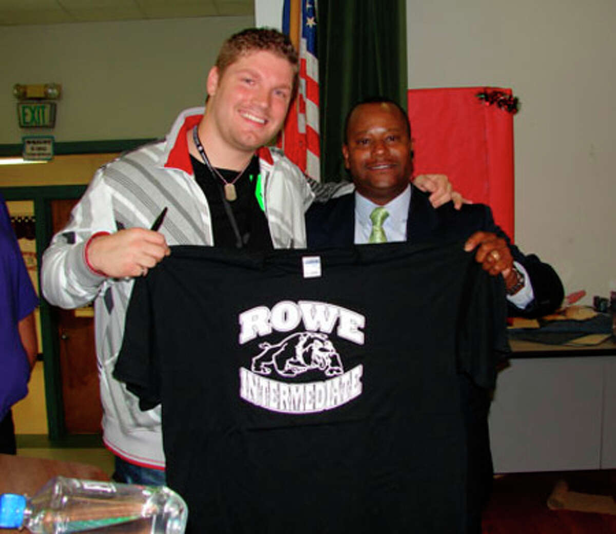 Courtesy photo Michael Sarver visited Rowe Campus Monday, April 27 to inspire the students to do well on the TAKS test. Pictured above, Sarver receives a Rowe T-shirt from Rowe Principal Victor Williams.