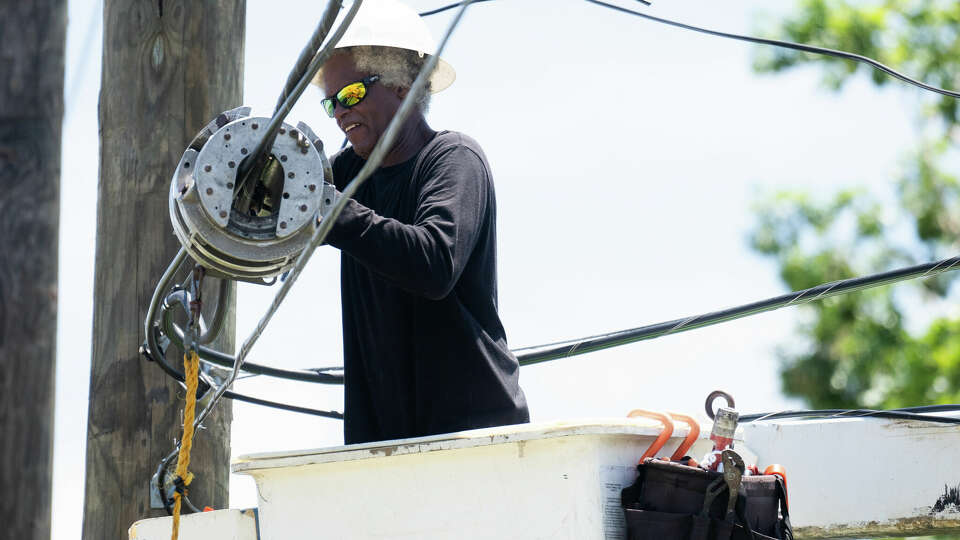 An electrical worker inspects a power line after Hurricane Beryl, Wednesday, July 10, 2024, in Conroe.