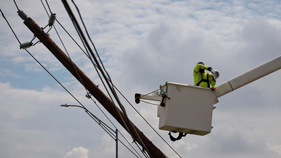 HOUSTON, TX - JULY 11: A CenterPoint foreign assistance crew worker wipes sweat from his brow as he works with others to restore power lines on July 11, 2024 in Houston, Texas. Nearly one million people still remain without electricity in the wake of Hurricane Beryl, which was a category one hurricane that made a direct hit on Houston and surrounding areas on July 8, leaving more than two million people without power. (Photo by Danielle Villasana/Getty Images)
