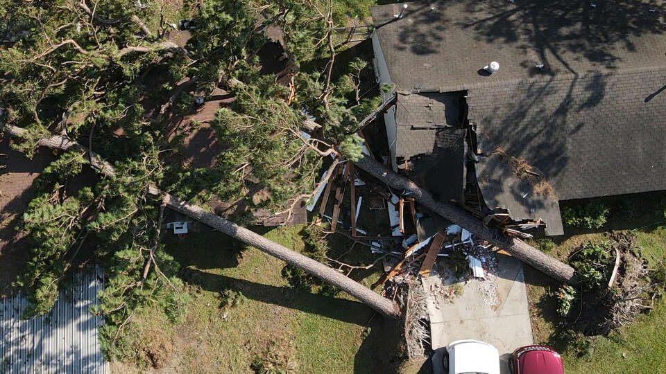 Trees that fell during Hurricane Beryl remain perched on a couple of houses in the Homestead neighborhood of Houston on Wednesday, July 10, 2024. (Jon Shapley/Houston Chronicle)