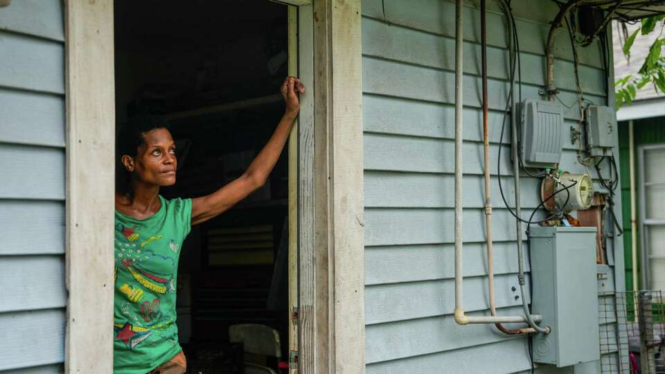 Stacy Humphrey, 48, is seen looking at fallen power lines outside of her home on Sunday, July 14, 2024 in Houston, seven days after Hurricane Beryl caused major power outages.