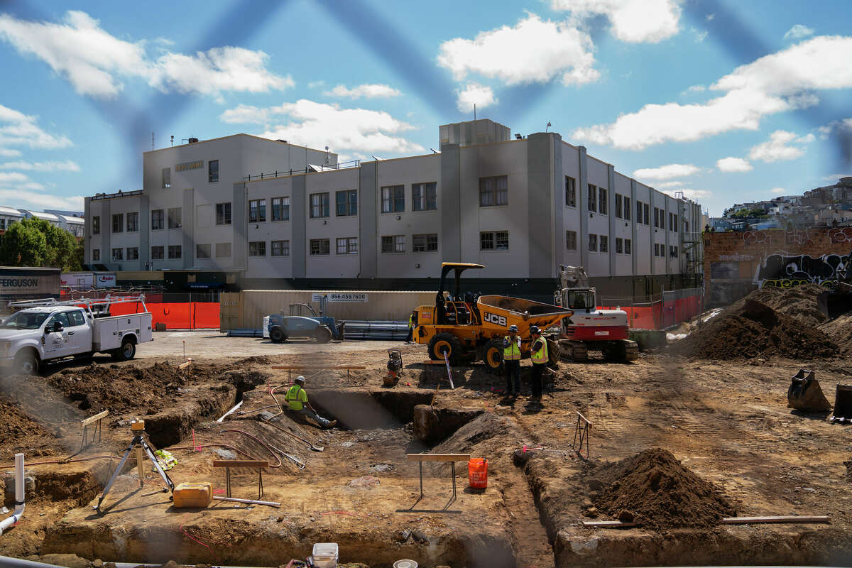 Construction workers dig for preparation of the elevator shaft and lay down piping at the property of 1633 Valencia St. in San Francisco on Tuesday, July 16, 2024.