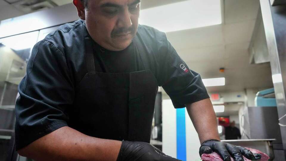 A Pico's kitchen staff prepares meat for their beef fajita as the restaurant is reopening after they lost electricity for a week Tuesday, July 16, 2024 in Houston. Pico’s is among restaurants joining Tony Buzbee's class action suit against CenterPoint Energy’s failure with electricity.