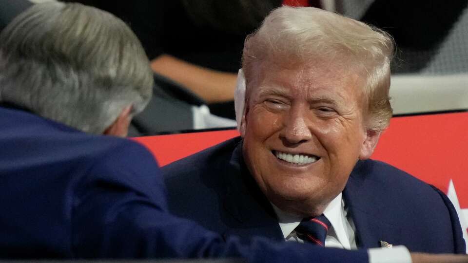 Republican presidential candidate former President Donald Trump talks to Texas Gov. Greg Abbott during the Republican National Convention Wednesday, July 17, 2024, in Milwaukee. (AP Photo/Charles Rex Arbogast)