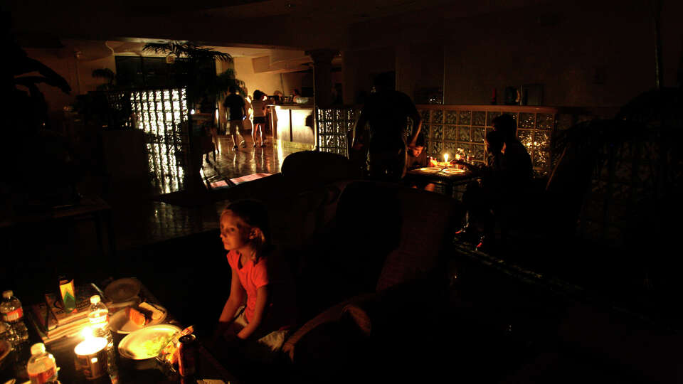 Sadie Addington, of New Braunfels, eats dinner at the Howard Johnson under candlelight after Hurricane Dolly came ashore norht of South Padre Island on Wednesday, July 23, 2008. The hotel provided a dinner of barbeque chicken to its guest that were stranded by the hurricane. The island was left with out power as were other parts of the Rio Grande Valley. 