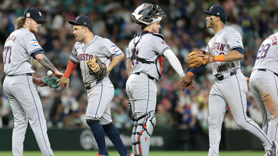 Houston Astros players, from left, pitcher Josh Hader (71), second baseman Jose Altuve, catcher Yainer Diaz and third baseman Alex Bregman celebrate after defeating the Seattle Mariners during a baseball game Friday, July 19, 2024, in Seattle. (AP Photo/Jason Redmond)