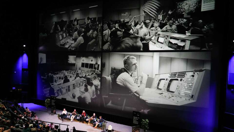 Images from mission control are seen as Gene Kranz, who served as flight director on Apollo 11, (second from right) speaks alongside Integrated Communications Officers Tom Hanchett, Ed Fendell and Flight Activities Director Spencer Gardner, during a celebration of the 55th anniversary of the Apollo 11 moon landing at Space Center Houston, Saturday, July 20, 2024, in Houston. The mission blasted off from Cape Kennedy on July 16, 1969, columnated in commander Neil Armstrong, command module pilot Michael collins and lunar module pilot Edwin 'Buzz' Aldrin’s landing on the moon on July 20 and ended when they splashed down safely back on Earth on July 24.