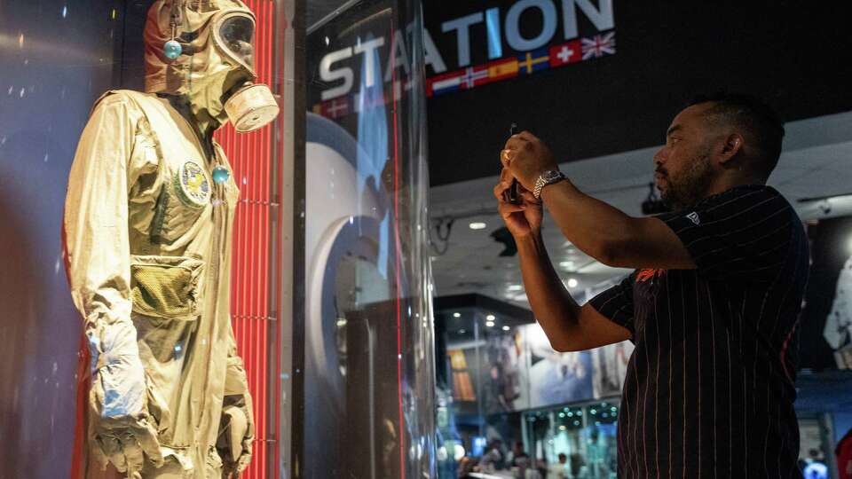 Julian Pardo takes a photo of the biological isolation garnet worn by Apollo 11 astronaut Mike Collins when he returned from the first moon landing at Space Center Houston, Saturday, July 20, 2024, in Houston. The mission blasted off from Cape Kennedy on July 16, 1969, columnated in commander Neil Armstrong and lunar module pilot Edwin 'Buzz' Aldrin’s landing on the moon on July 20 and ended when they and command module pilot Michael Collins splashed down safely back on Earth on July 24.