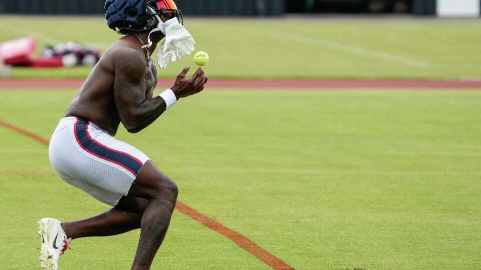 Houston Texans wide receiver Steven Sims catches a tennis ball as he runs through a catching drill during an NFL training camp Saturday, July 20, 2024, in Houston.