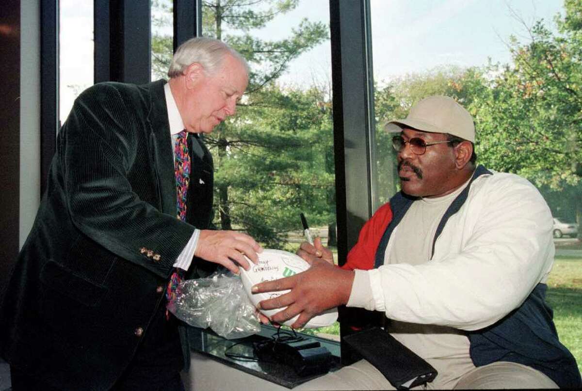 Actor and former Michigan State University football player Bubba Smith, right, hands back a football he autographed for Terry Braverman, director of the university's fund-raising arm, while attending the dedication of the new athletic Hall of Fame at the Clara Bell Smith Academic Center in East Lansing, Mich., Friday, Oct. 1, 1999. Both were on hand for the dedication. (AP Photo/Daymon J. Hartley)