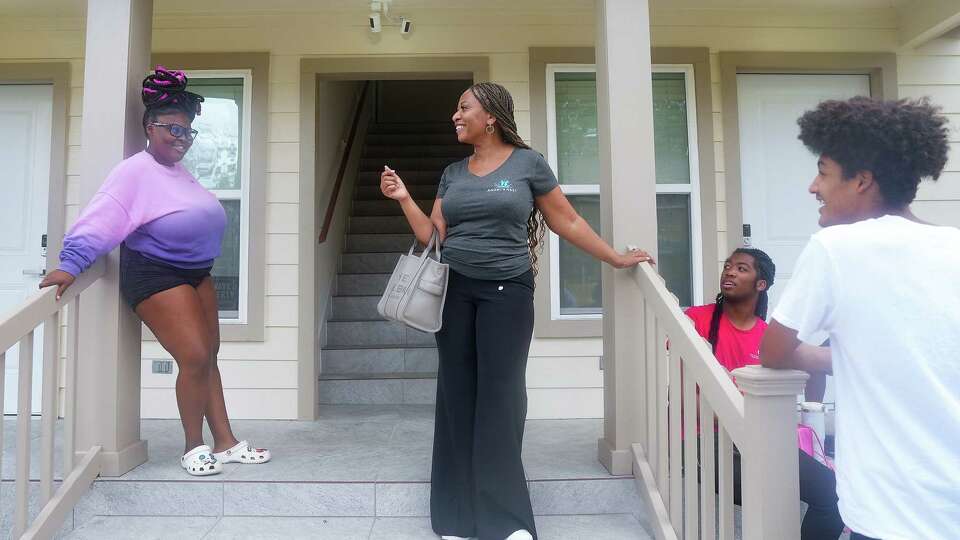 Angel’s Nest founder Malika Bruno, second from left, talks with apartment residents including Toni Chamberlayner, 18, Javon Jackson, 18 and Josiah Gonzalez, 18, on Monday, July 22, 2024 in Houston. Angel's Nest is a nonprofit that aims to help young adults transition out of foster care and into furthering their education and careers.