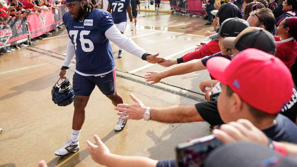 Houston Texans guard Kenyon Green (76) high five fans as he walks to practice during an NFL training camp Tuesday, July 23, 2024, in Houston.