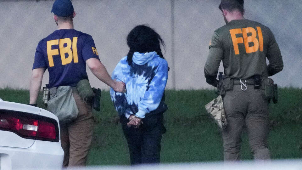 A person is detained by FBI agents during a large multi-agency operation Wednesday, July 24, 2024, at NRG Arena in Houston.