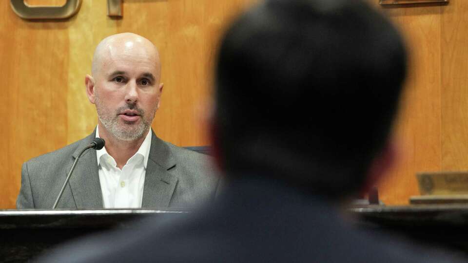 Public Utility Commission of Texas Chairman Thomas Gleeson speaks to CenterPoint Energy CEO Jason Wells during a PUC meeting Thursday, July 25, 2024, in the Commissioners Hearing Room at the William B. Travis State Office Building in Austin.