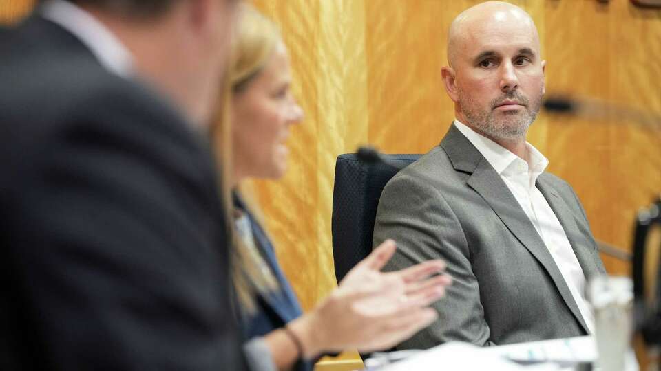 Public Utility Commission of Texas Chairman Thomas Gleeson listens to Commissioner Courtney Hjaltman as she questions a team from CenterPoint Energy, including CEO Jason Wells, during a PUC meeting Thursday, July 25, 2024, at in the Commissioners Hearing Room at the William B. Travis State Office Building in Austin.