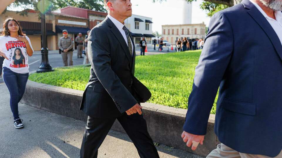 Former Uvalde Consolidated Independent School District police officer Adrian Gonzales, center, leaves the Uvalde County Courthouse as Cristine Olivarez, mother of Robb Elementary survivor Kendall Olivarez, walks behind him on Thursday morning, July 25, 2024, in Uvalde, Texas. Gonzales pleaded not guilty to 29 counts of child endangerment after being indicted by a Uvalde grand jury for his role in the Robb Elementary mass shooting.