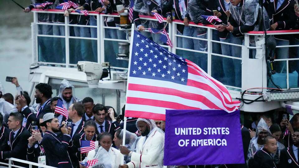 United States' Coco Gauff and Lebron James, bottom center, travel with teammates along the Seine River in Paris, France, during the opening ceremony of the 2024 Summer Olympics, Friday, July 26, 2024. (AP Photo/Kirsty Wigglesworth)