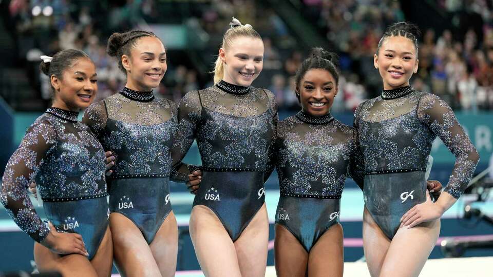 Team USA from left to right, Jordan Chiles, Hezly Rivera, Jade Carey, Simone Biles and Sunisa Lee pose for photos after competing in the women's artistic gymnastics qualification round at Bercy Arena at the 2024 Summer Olympics, Sunday, July 28, 2024, in Paris, France. (AP Photo/Abbie Parr)