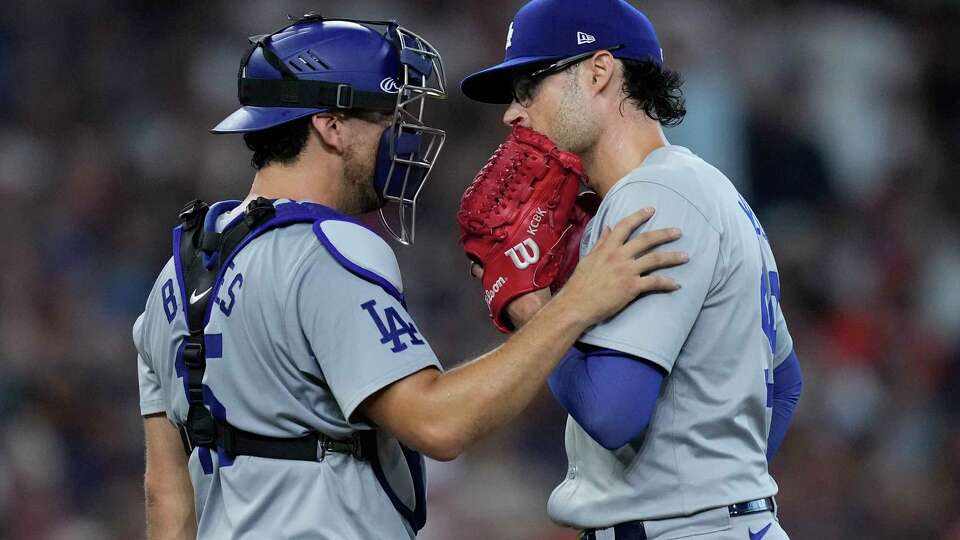 Los Angeles Dodgers catcher Austin Barnes talks with relief pitcher Joe Kelly at the mound during the eighth inning of a baseball game against the Houston Astros, Sunday, July 28, 2024, in Houston. (AP Photo/Kevin M. Cox)