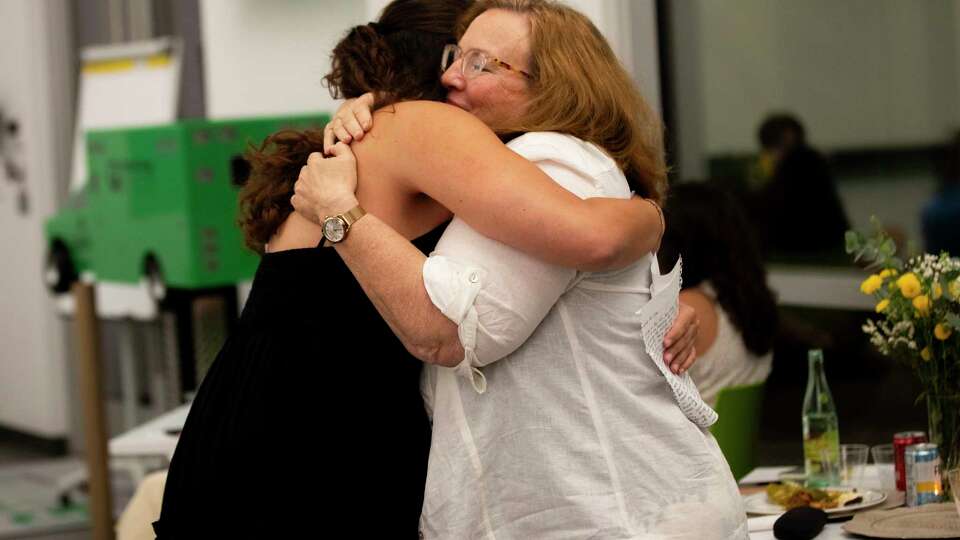 Host parents hug their students during Creating Friendships For Peace's farewell dinner, Saturday, July 27, 2024, in The Woodlands.