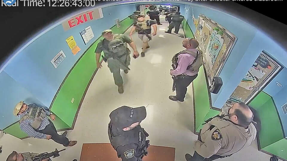 In this photo from surveillance video provided by the Uvalde Consolidated Independent School District via the Austin American-Statesman, authorities stage in a hallway as they respond to the shooting at Robb Elementary School in Uvalde, Texas, May 24, 2022. (Uvalde Consolidated Independent School District/Austin American-Statesman via AP)