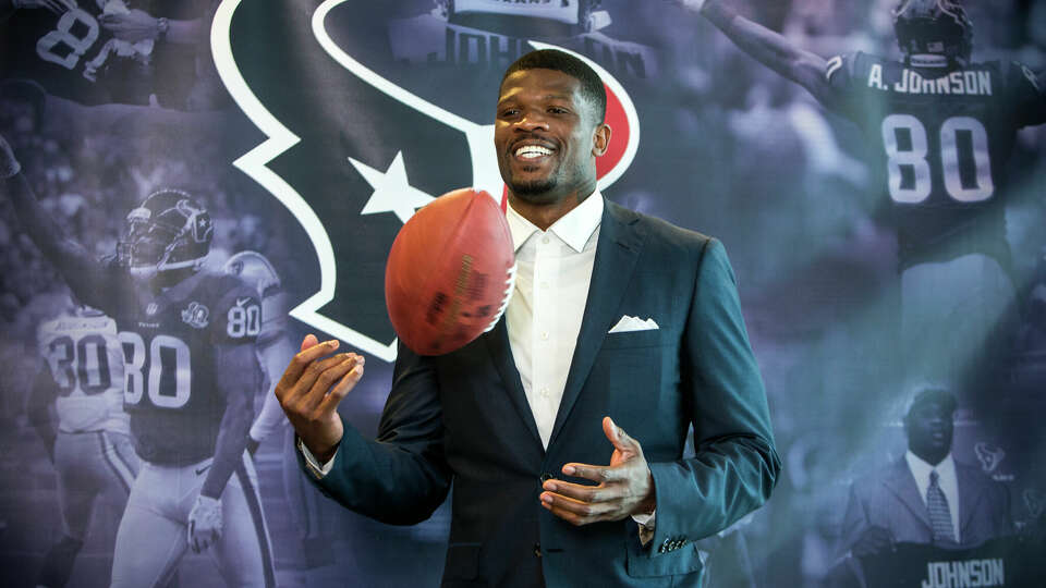 Former Houston Texans wide receiver Andre Johnson tosses a football in the air as he waits to pose for photos following his retirement ceremony at NRG Stadium on Wednesday, April 19, 2017, in Houston. Johnson signed a one-day contract to retire as a Texans player. ( Brett Coomer / Houston Chronicle )