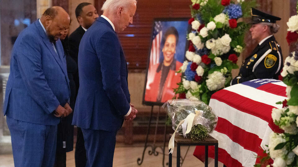 President Joe Biden prays by the flag-draped coffin of the late Congresswoman Sheila Jackson Lee, with her widower, Elwyn Lee and children Erica Lee and Jason Lee, in the rotunda of Houston City Hall Monday, July 29, 2024, in Houston. Jackson Lee died on July 19 after battling pancreatic cancer.