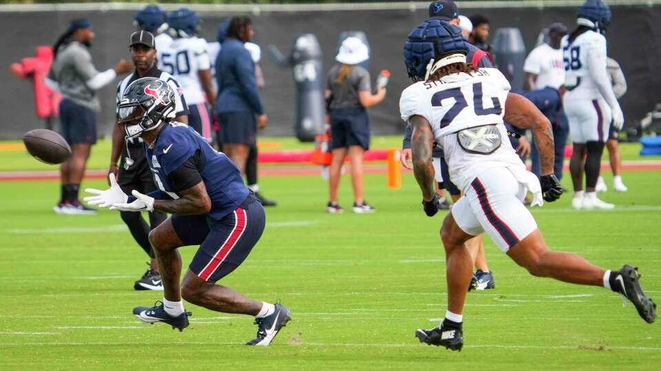 Houston Texans wide receiver Stefon Diggs (1) turns to make a catch against cornerback Derek Stingley Jr. (24) during an NFL training camp Tuesday, July 30, 2024, in Houston.