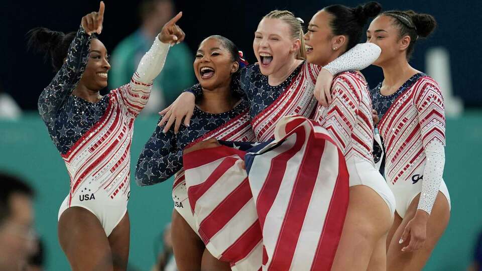 Members of Team USA celebrate after winning the gold medal during the women's artistic gymnastics team finals round at Bercy Arena at the 2024 Summer Olympics, Tuesday, July 30, 2024, in Paris, France. (AP Photo/Abbie Parr)