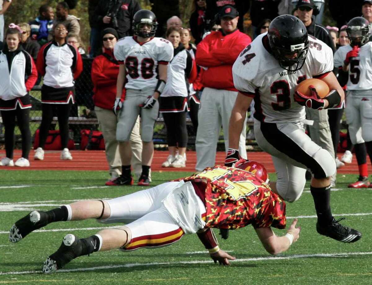 Fairfield Warde's David Wolff breaks a tackle from St. Joseph player Tyler Matakevich during Saturday's game at St. Joseph's in Trumble.