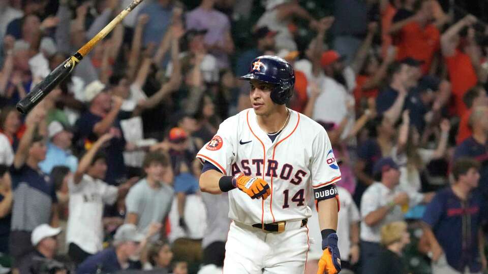 Houston Astros pinch-hitter Mauricio Dubon (14) flips his bat after his two-run home run during the sixth inning of an MLB baseball game at Minute Maid Park on Wednesday, July 31, 2024, in Houston.