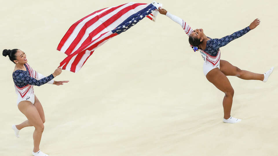 \Sunisa Lee (L) and Jordan Chiles (R) of Team United States celebrate with the national flag after winning the gold medals during the Artistic Gymnastics Women's Team Final on day four of the Olympic Games Paris 2024 at Bercy Arena on July 30, 2024 in Paris, France.