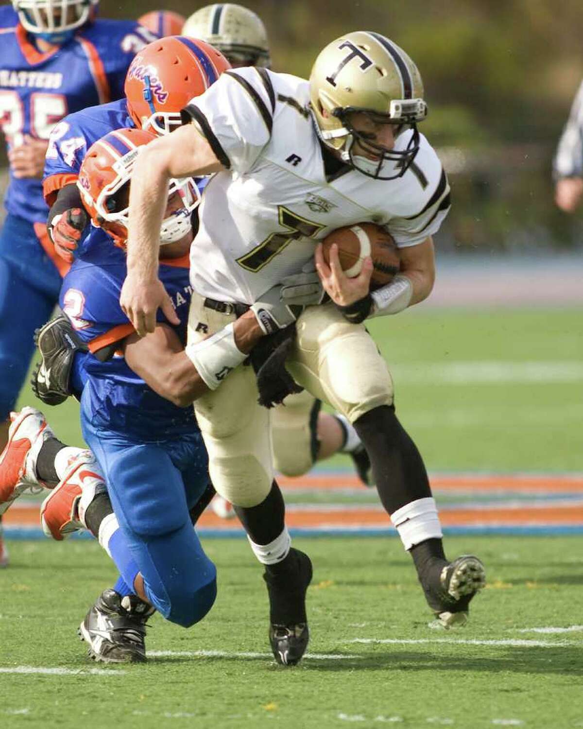Trumbull's Ian Milne picks up yardage with Danbury's Aaron Dixon hanging on to make the stop during their FCIAC game Saturday, Oct. 30, 2010, at Danbury High School.