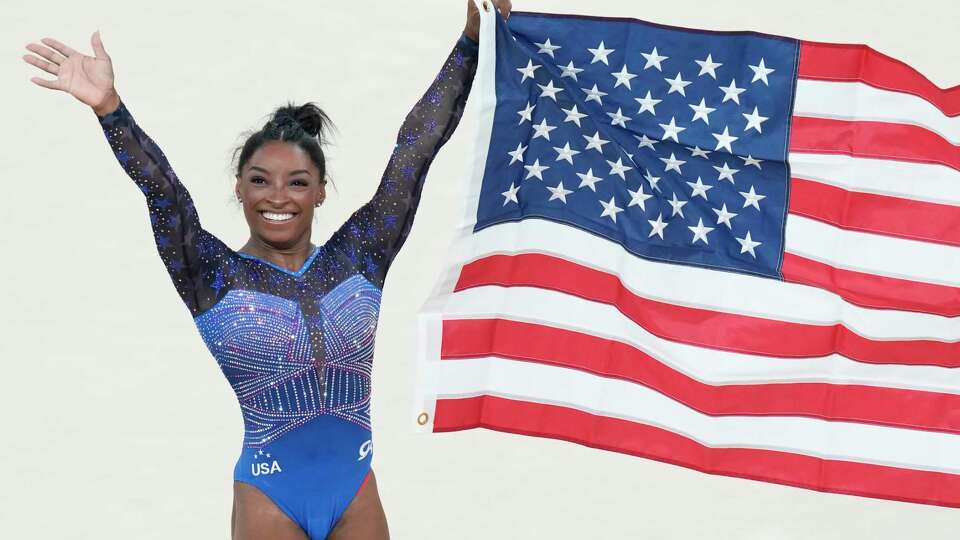 Simone Biles, of the United States, celebrates after winning the gold medal during the women's artistic gymnastics all-around finals in Bercy Arena at the 2024 Summer Olympics, Thursday, Aug. 1, 2024, in Paris, France. (AP Photo/Francisco Seco)