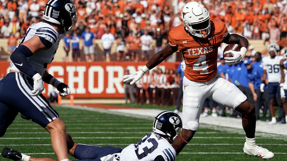 Texas running back CJ Baxter (4) tries to side step BYU safety Raider Damuni (33) during the first half of an NCAA college football game in Austin, Texas, Saturday, Oct. 28, 2023. (AP Photo/Eric Gay)