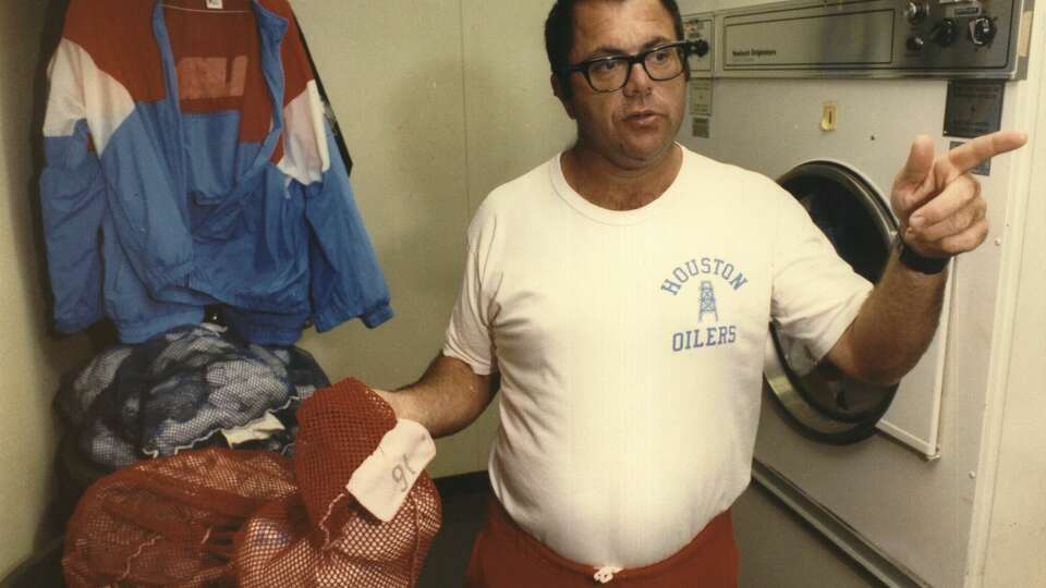 Houston Oilers equipment assistant Bill 'Mojo' Lackey prepares to do laundry after a game in 1991.