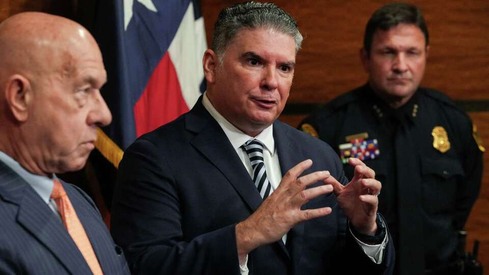 Noe Diaz, center, the incoming chief of the Houston Police Department, speaks to a reporter during a press conference with Mayor John Whitmire, left, and interim HPD Chief Larry Satterwhite, right, during a press conference Diaz as the new chief Friday, Aug. 2, 2024, at Houston City Hall in Houston.