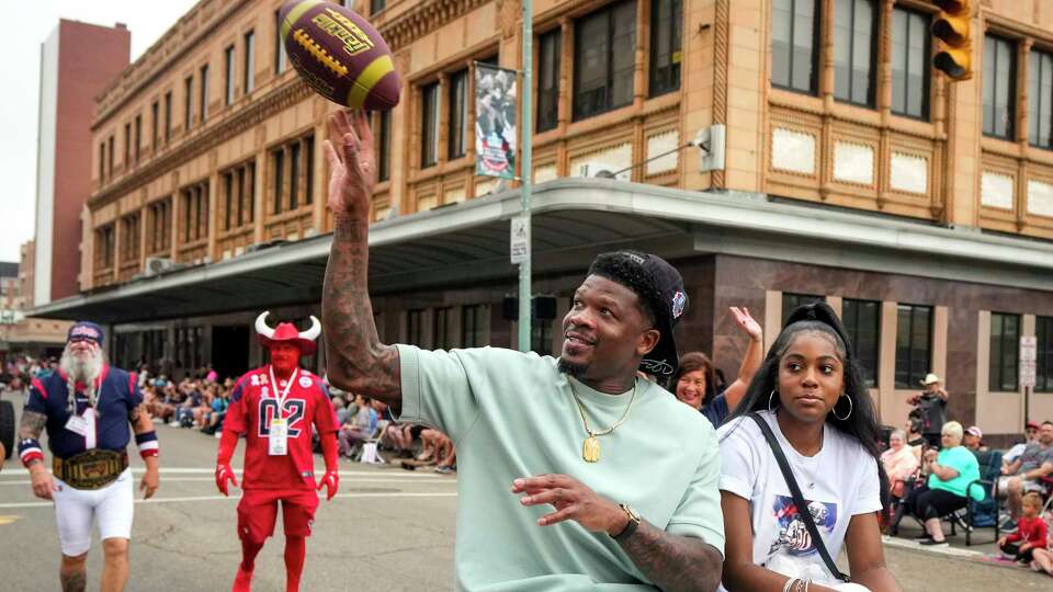 Hall of Fame wide receiver Andre Johnson tosses a football to a fan as he rides in the Pro Football Hall of Fame Grand Parade with his daughter, Kylie, and Gary Kubiak on Saturday, Aug. 3, 2024 in Canton, Ohio. Johnson is the first Texans player to be inducted into the Hall of Fame.