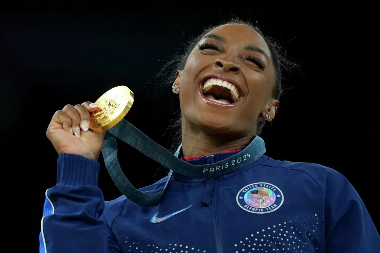 Simone Biles, of the United States, celebrates after winning the gold medal at the medal ceremony during the women's artistic gymnastics individual vault finals at Bercy Arena at the 2024 Summer Olympics, Saturday, Aug. 3, 2024, in Paris, France. (AP Photo/Francisco Seco)