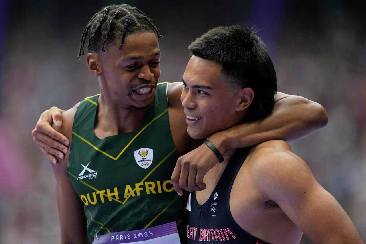 Shaun Maswanganyi, of South Africa, left, and Louie Hinchliffe, of Britain, react after qualifying in a men's 100 meters round 1 heat at the 2024 Summer Olympics, Saturday, Aug. 3, 2024, in Saint-Denis, France. (AP Photo/Ashley Landis)