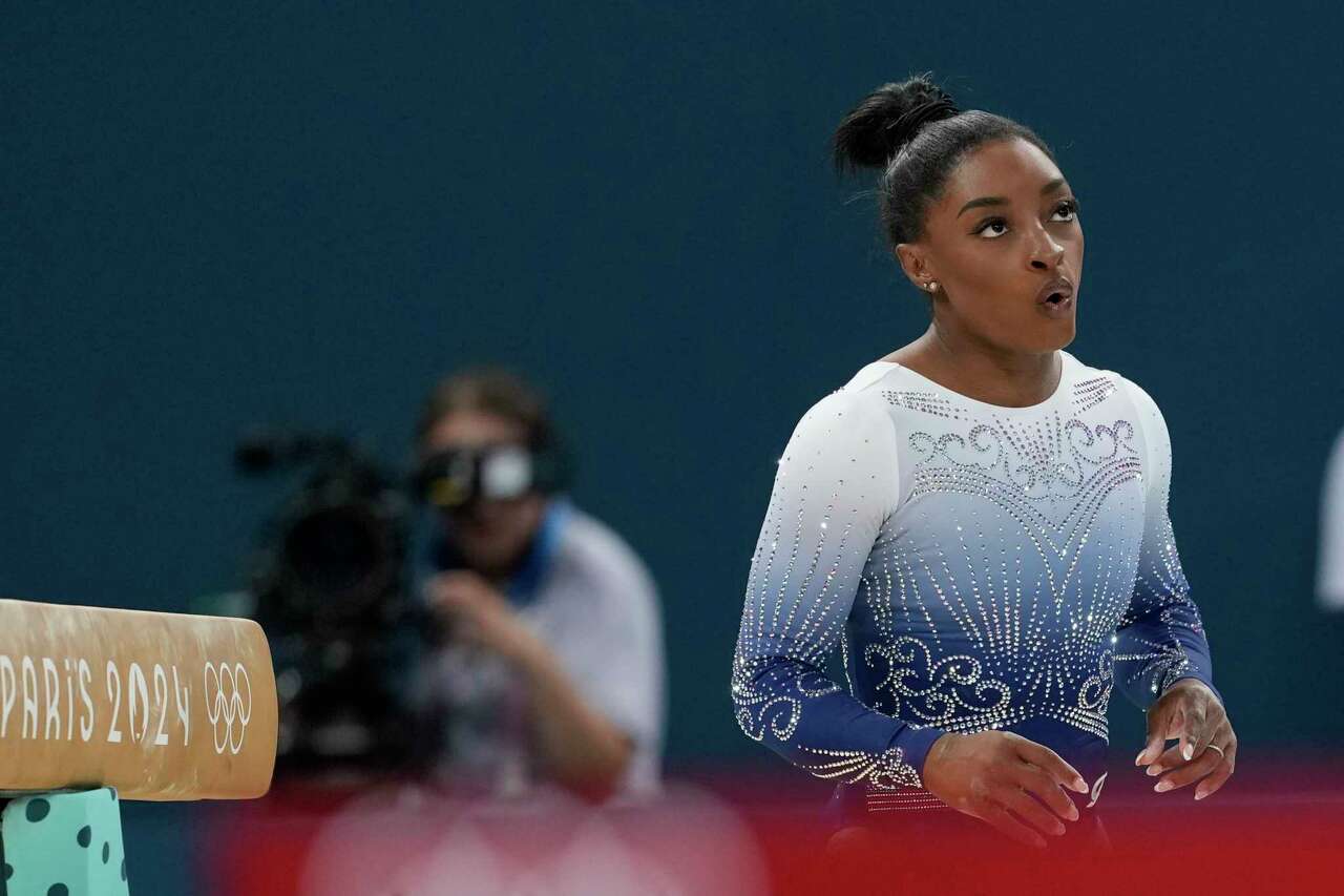 Simone Biles, of the United States, reacts after falling while competing during the women's artistic gymnastics individual balance beam finals at Bercy Arena at the 2024 Summer Olympics, Monday, Aug. 5, 2024, in Paris, France. (AP Photo/Charlie Riedel)