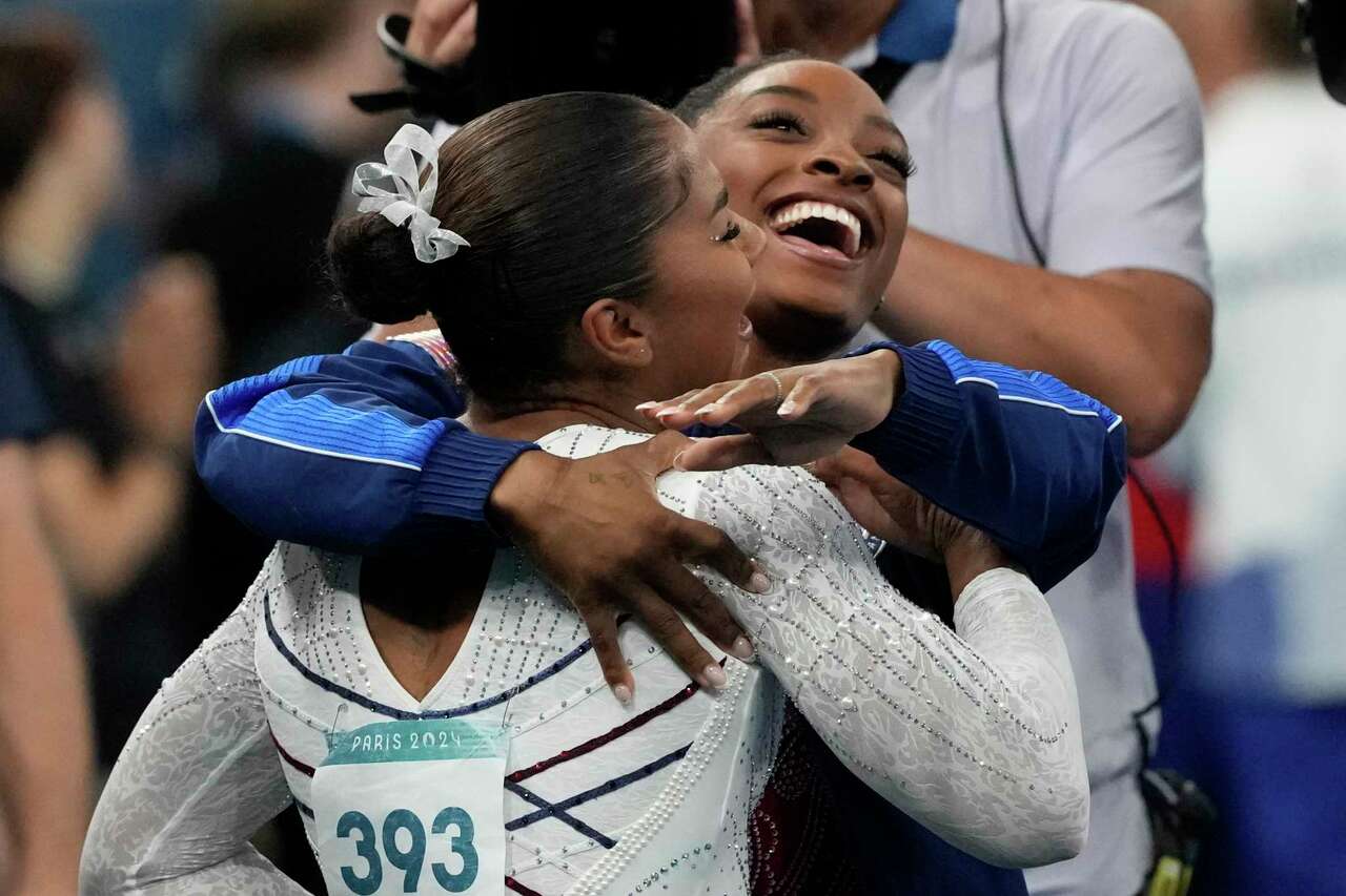 Jordan Chiles (393), of the United States, reacts to seeing she won the bronze medal as she gets a hug from teammate Simone Biles during the women's artistic gymnastics individual floor finals at Bercy Arena at the 2024 Summer Olympics, Monday, Aug. 5, 2024, in Paris, France. (AP Photo/Charlie Riedel)