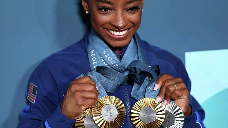 PARIS, FRANCE - AUGUST 05: Simone Biles of Team United States poses with her Paris 2024 Olympic medals following the Artistic Gymnastics Women's Floor Exercise Final on day ten of the Olympic Games Paris 2024 at Bercy Arena on August 05, 2024 in Paris, France.