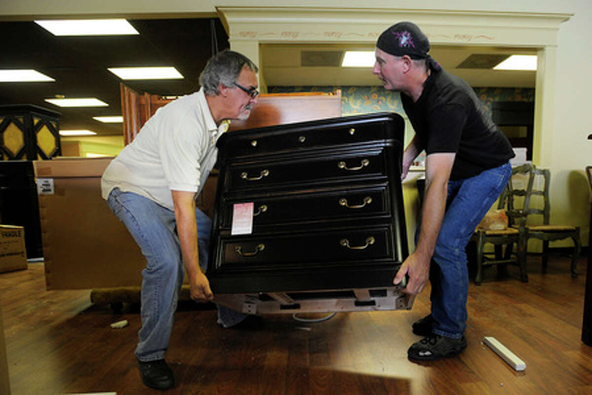 Ebb Moore, owner of Parlours in Orange, and employee, David Franklin, ready new furniture for a reopening after Thanksgiving. Valentino Mauricio/The Enterprise